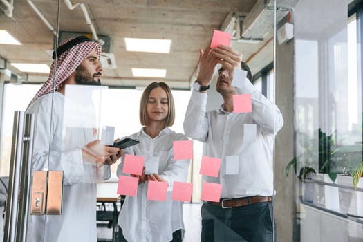 Using stickers on the ,glass. Muslim businessman in traditional outfit with colleagues in office photo