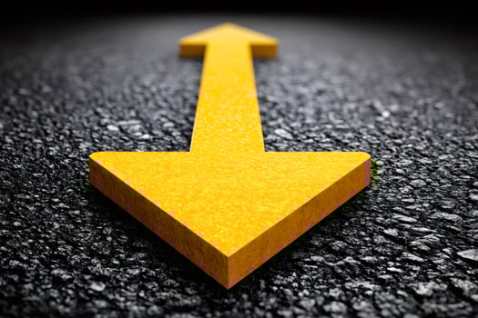 Double yellow arrow is pointing in opposite directions on asphalt road photo