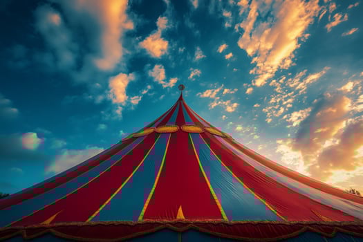 Circus tent top against dramatic sunset sky with clouds photo