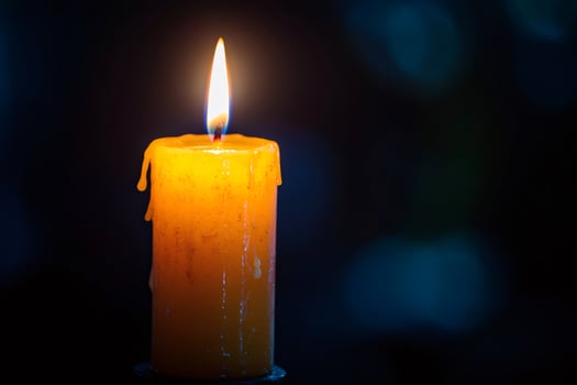 Burning candle melting on dark background symbolizing hope and remembrance photo