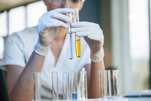 Experimenting with chemicals, in ,test tubes. Female doctor in white coat is indoors photo