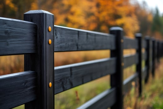 Black wooden fence protecting ranch in autumn scenery photo