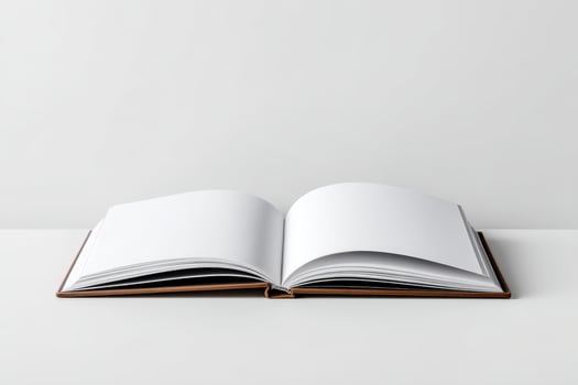 Open blank book displaying empty pages on a minimalist surface in a bright setting photo