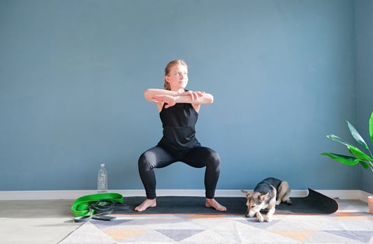young athletic woman squatting at home photo