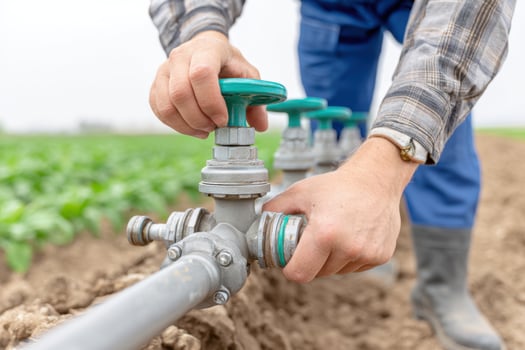 Farmer operating irrigation valve in field for efficient water management and crop growth promoting sustainable agriculture practices and water conservation concept photo