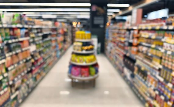 Blurry image of a grocery store with many shelves and displays photo