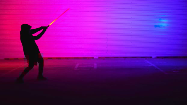 A striking neon silhouette illuminated by light in a bustling urban environment at night. Media photo