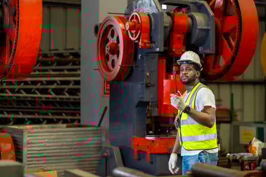 African American industrial worker is using walkie talkie while working inside the metal sheet galvanized roof factory for safety industry photo