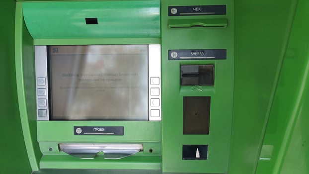 Dnipro, Ukraine - April 26, 2025 - Green atm machine with card slot and screen for financial transactions. accessible banking, technology in everyday life, convenience of cash withdrawal photo