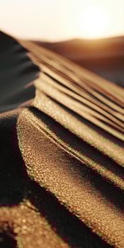 The sun is setting over a desert sand dune photo