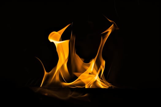 Vivid yellow and orange flames dancing in dark background photo