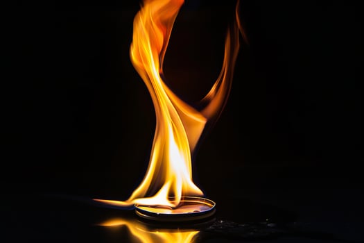 Vivid flames emanating from lighter against dark background photo