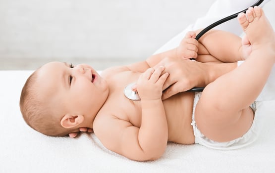 Medical checkup. Doctor pediatrician examining little baby with stethoscope in clinic photo