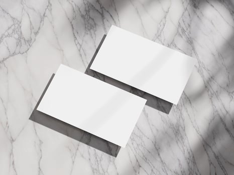 Two pristine business cards lying on a smooth marble surface, perfect for sophisticated branding. photo