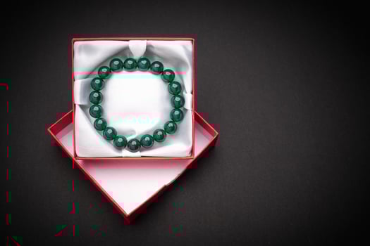 Close-up of a jade bangle or bracelet in a red box on a black background. photo