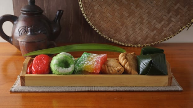 A wooden tray full of delicious traditional market snacks from Indonesia photo