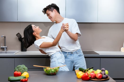 Cheerful Asian Couple Cooking And Dancing Having Fun While Preparing Dinner Together In Modern Kitchen, Having Romantic Date At Home. Family Weekend Leisure, Food Preparation Concept photo
