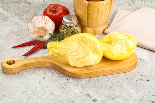 A wooden cutting board with a knife, pepper, and garlic photo