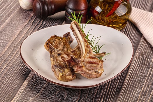 Grilled lamb chops on a plate with olive oil and garlic photo