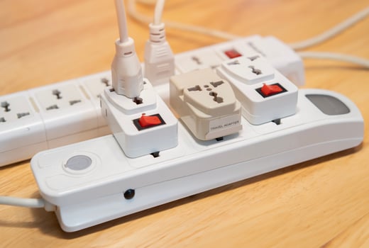 Cropped image of extension cord on wooden floor at home. Electrician's equipment concept. photo