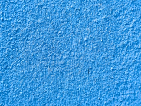 Textured blue painted wall surface with rough finish photo