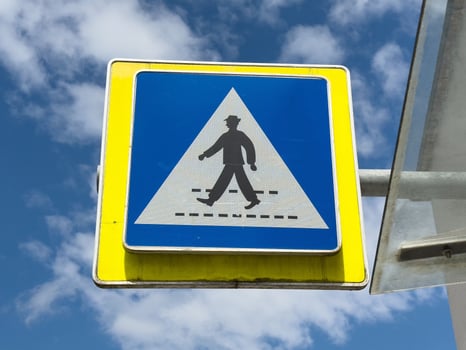 Pedestrian crossing traffic sign against blue sky background photo
