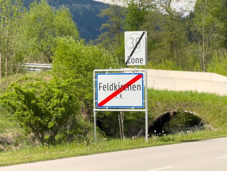 End of feldkirchen town zone sign against scenic mountain landscape photo
