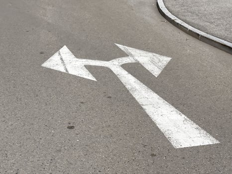 Directional arrows on urban asphalt road surface with curve photo