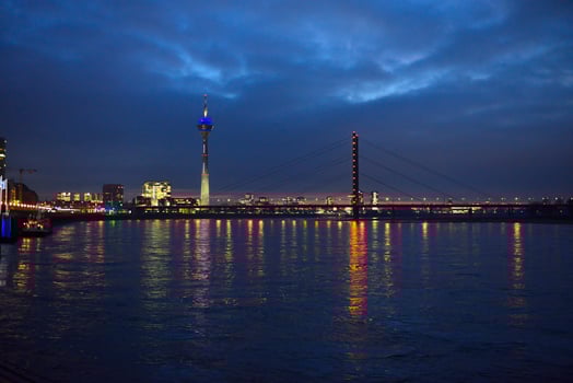 City skyline at night, with a bridge over calm water photo
