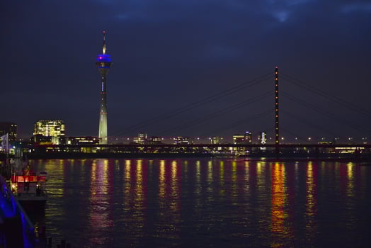 A scenic bridge overlooks water with a vibrant city skyline photo