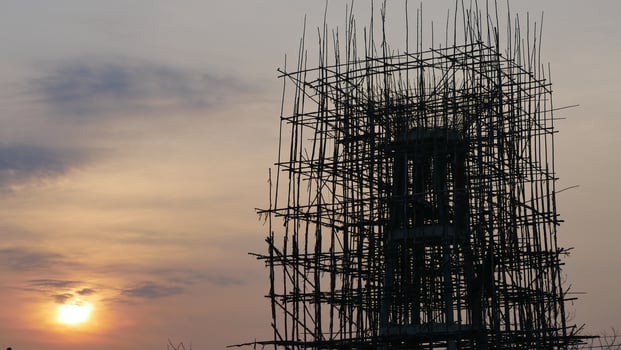 A scaffolding structure silhouetted against sunset sky, showcasing intricate wooden b photo