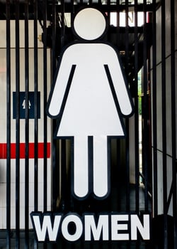 Women's Restroom Sign with Minimalist Design on Metal Gate Background in Urban Setting photo