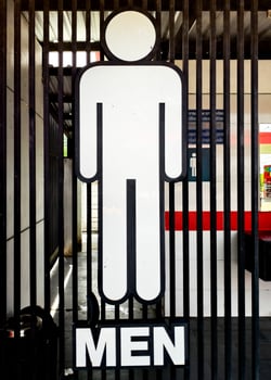 Minimalist Men's Restroom Sign on Black Metal Bars with Bold White Figure and Text in Urban Setting photo