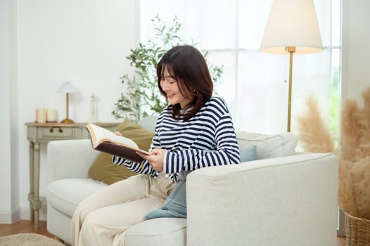 Young Woman Enjoys Reading a Book in a Cozy Living Room Setting photo