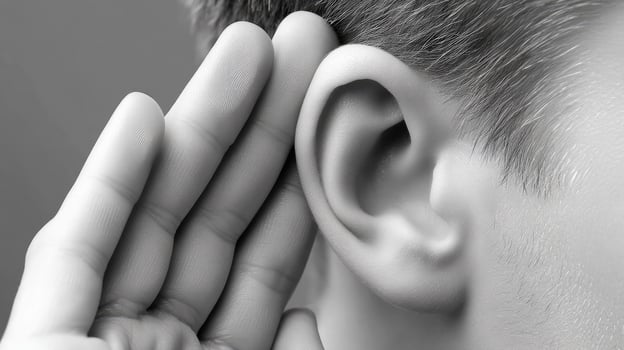 A person is holding their ear to their ear photo