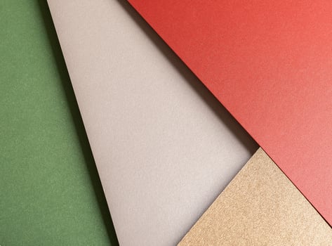 Paper background with matte texture. Layered diagonal sheets in crimson red, champagne, soft beige, photo