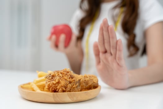 slim femaleconfuse French fries and fried chicken. Woman in restaurant achieves weight loss goal for healthy life, crazy about thinness, thin waist, nutritionist. Diet, body shape. photo