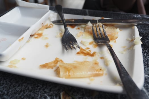 Empty plate with forks after a meal at a busy restaurant photo