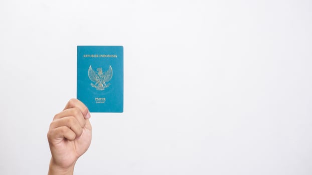 Yogyakarta, Indonesia, 2025 - Man hand holding Indonesian passport isolated on white background photo