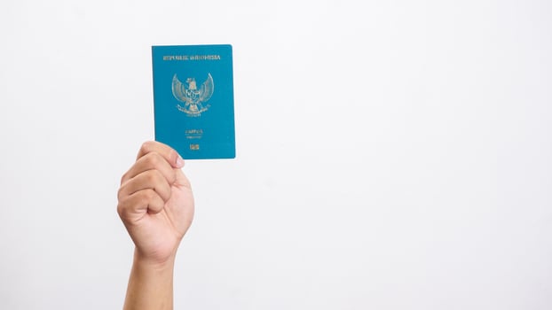 Yogyakarta, Indonesia, 2025 - Hand showing Indonesian passport document isolated on white background photo