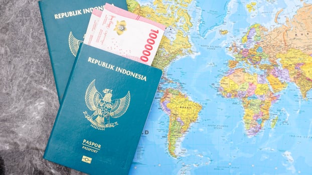 Yogyakarta, Indonesia, 2025 - Indonesian passports with Indonesia Rupiah banknotes and world map isolated on marble pattern background photo