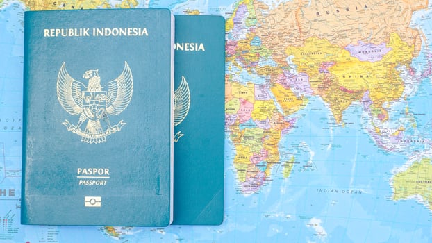 Yogyakarta, Indonesia, 2025 - Indonesian passports isolated on world map background photo