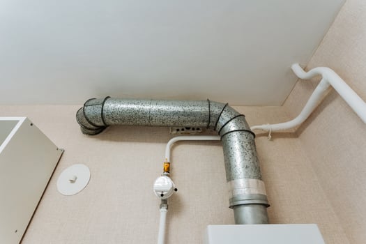 A metal pipe is currently suspended from the ceiling of a room, creating an intriguing focal point that may be part of the plumbing system or the infrastructure of the space photo