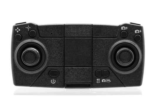 A full shot of a black drone controller, showcasing its compact design and various controls. photo