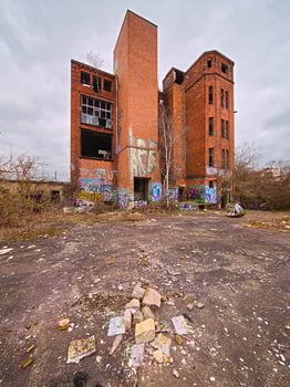 Abandoned brick factory in Germany with graffiti-covered walls, broken windows, and overgrown surroundings photo