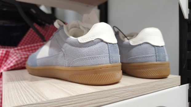 Stylish blue and white sneakers with gum soles on display shelf photo