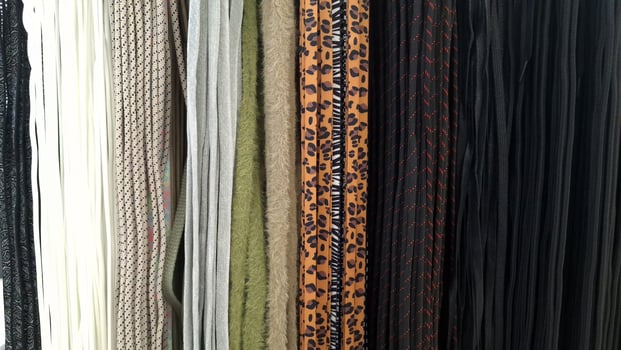 A variety of textile shoe laces in different colors and patterns, hanging in a row photo