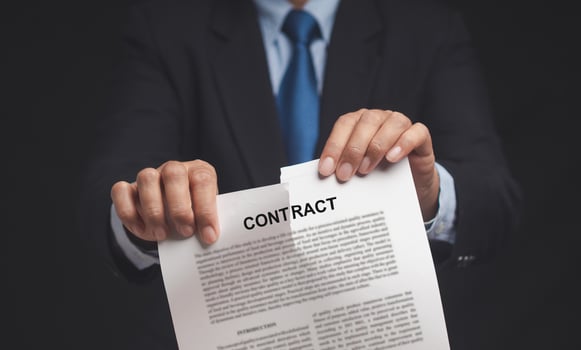 Canceled contract. Businessman is tearing up a contract while standing in the office photo