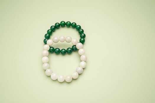 Top view of white and green jade rings on a green background photo