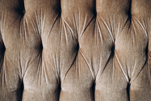 Textile pattern featuring tufted fabric in neutral brown tones with intricate details photo